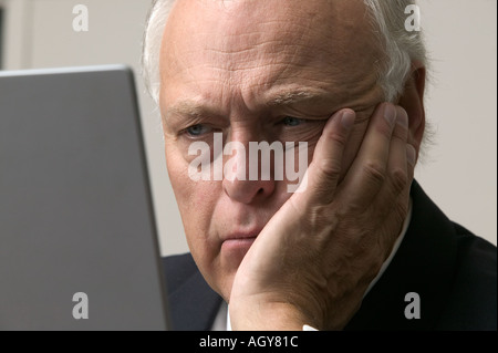 Invecchiamento Corporate executive recensioni informazioni sul computer portatile in edificio per uffici Foto Stock