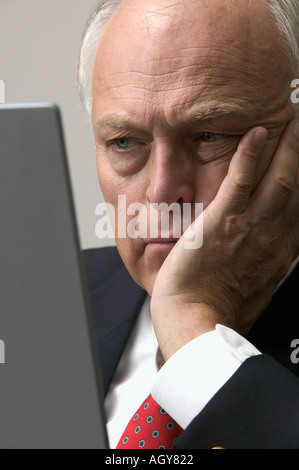 Invecchiamento Corporate executive recensioni informazioni sul computer portatile in edificio per uffici Foto Stock