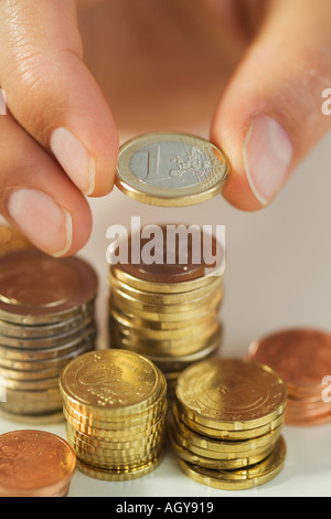 Uomo di impilamento delle monete in euro Foto Stock