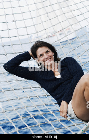 Ritratto di una metà donna adulta giacente in un amaca Foto Stock