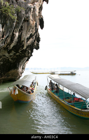 Battelli turistici che arrivano a James Bond Island Ko Khao Ping Kan torrioni di roccia in background Phuket Thailandia Foto Stock