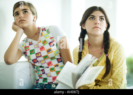 Giovani amici di sesso femminile azienda prenota insieme, guardando lontano Foto Stock