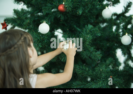 Ragazza decorare albero di Natale Foto Stock