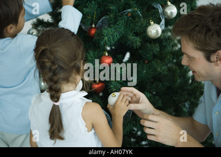 Famiglia decorare albero di Natale Foto Stock