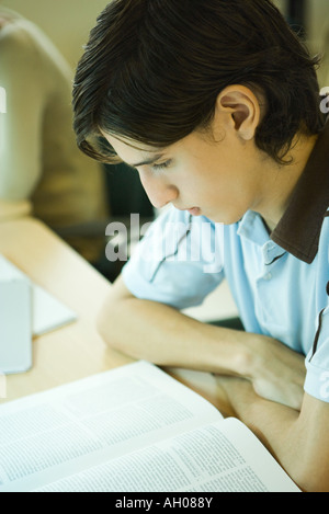 Giovane uomo studiare in biblioteca universitaria Foto Stock