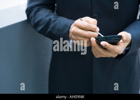 Imprenditore utilizzando palmtop, vista ritagliata delle mani Foto Stock
