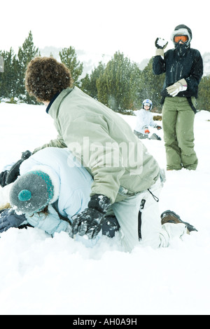 Giovani amici di lotta con le palle di neve nella neve Foto Stock