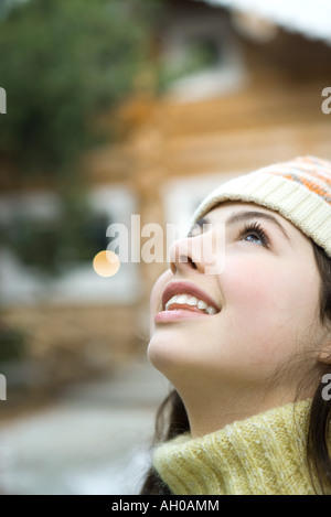 Ragazza adolescente guardando in alto, close-up, chalet in background Foto Stock