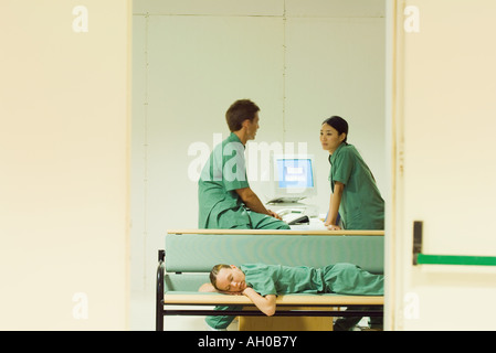 Lavoratori medici chiacchierando in ufficio, sdraiato su un banco di lavoro, con gli occhi chiusi Foto Stock