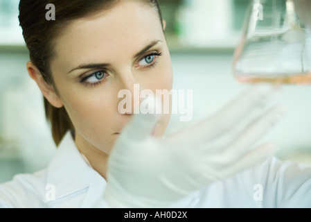 Giovane ricercatore femmina tenendo su pallone, close-up Foto Stock