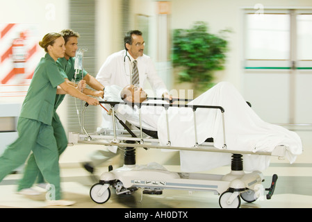 Sala di emergenza personale spingendo l uomo sulla barella, movimento sfocato Foto Stock