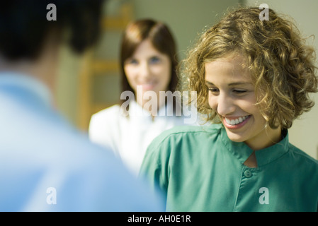 Giovane donna sorridente, guardando verso il basso, il fuoco selettivo Foto Stock