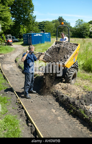 Lavoratori creazione nuovo percorso attraverso boschi utilizzando toptrek Foto Stock