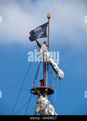 Il Teschio e Ossa Jolly Roger pirati bandiera sventola nel montante di Tall Ship Foto Stock