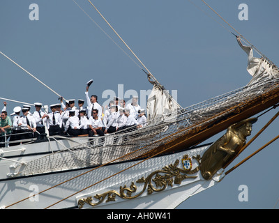 Bianco marinai in uniforme sulla prora di Sagres II Tall Ship uno di loro agitando il suo cappello Sail Amsterdam 2005 Foto Stock