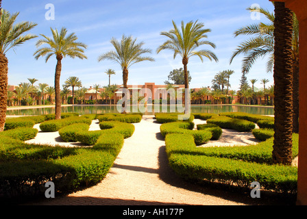 Il Marocco , Marrakesch , l'esclusivo Hotel Amanjena, giardino , pesce centrale piscina circondata da palme , padiglioni e ville Foto Stock