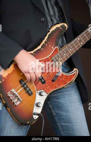 Questa vecchia chitarra un battere ben indossati chitarra elettrica essendo suonato sul palco da un anonoymous jean e camicia uomo placcati Foto Stock