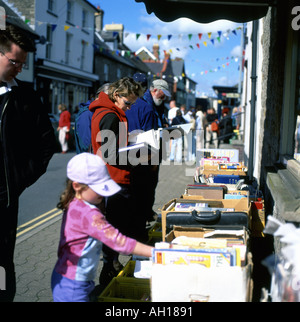 Famiglia e bambini shopping guardando i libri su una bancarella al di fuori di un Hay-on-Wye book shop durante il Festival di fieno, Wales, Regno Unito KATHY DEWITT Foto Stock