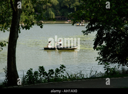 Giovane ebreo Hasidic matura in noleggio barca su Central Park Lake, New York City. L'uomo è il canottaggio la barca. Foto Stock