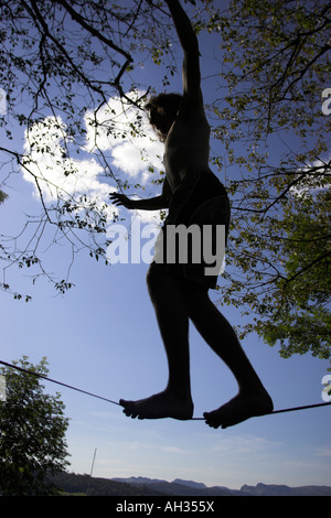 Sam Hill Slacklining è un equilibrio lo sport che utilizza il nastro di nylon tesa tra due punti di ancoraggio DEL DISTRETTO DEL LAGO Foto Stock