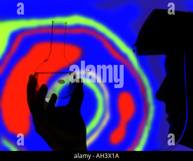 Il tecnico indossa facciale esaminando bicchiere di liquido Foto Stock