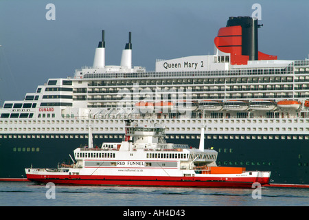 Queen Mary 2 su Southampton acqua al fianco di Nana è rosso di imbuti roll on roll off nave Aquila Rossa England Regno Unito Foto Stock