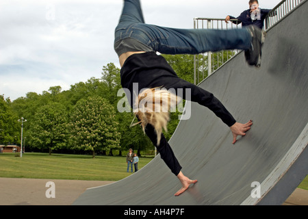 Giovane uomo o ragazzo facendo trick stunt summersault salti su pattini battenti a metà in aria Foto Stock