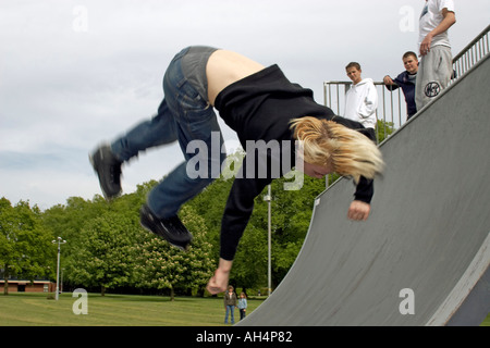 Giovane uomo o ragazzo facendo trick stunt summersault salti su pattini battenti a metà in aria Foto Stock