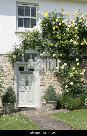 Una casa con rose intorno alla porta anteriore nel villaggio di Haddenham Foto Stock