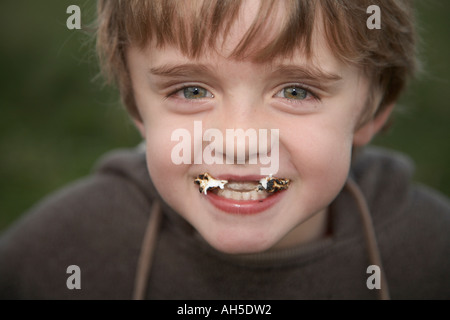 Ragazzo con la bocca piena di dolci Foto Stock