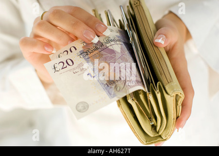 Donna con 20 pound note in borsa Foto Stock