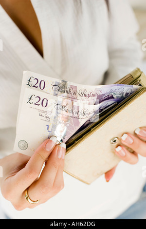 Donna con 20 pound note in borsa Foto Stock