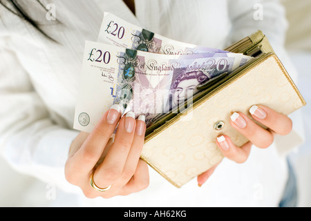 Donna con 20 pound note in borsa Foto Stock