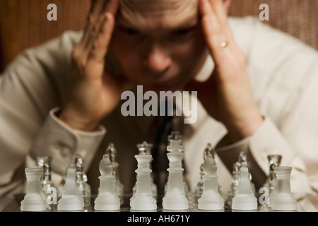 Uomo di concentrare su un gioco di scacchi Foto Stock