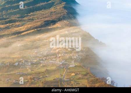 La nebbia che fluisce oltre Cemoro Lawang e nel cratere Gunung Bromo o Monte Bromo area Indonesia Java Foto Stock