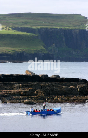 I turisti sulla gara di voce al di fuori del porto di Doolin per soddisfare la Doolin - Isole Aran traghetto, County Clare, Repubblica di Irlanda Foto Stock