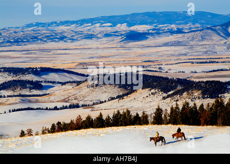 Due uomini a cavallo su una coperta di neve hill Foto Stock