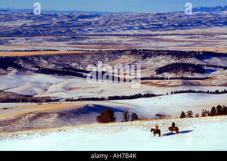 Due uomini a cavallo su una coperta di neve hill Foto Stock