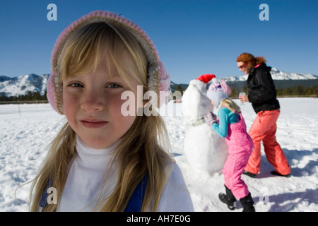 Ritratto di una ragazza con la madre e la sorella in background Foto Stock