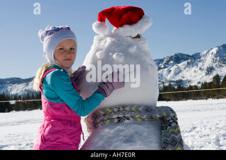 Ragazza costruire un pupazzo di neve Foto Stock