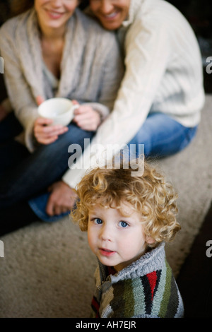 Ritratto di un ragazzo con i suoi genitori seduti dietro di lui Foto Stock