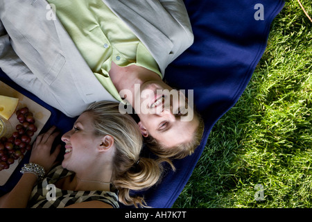 Angolo di alta vista di una giovane coppia giacendo in un parco e sorridente Foto Stock