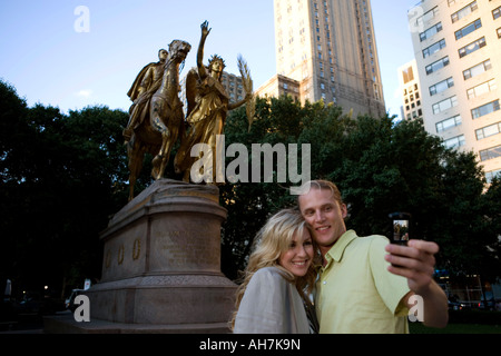 Basso angolo vista di una giovane coppia di scattare una foto di se stessi con un telefono cellulare, Central Park, Manhattan, New York City, nuova Foto Stock