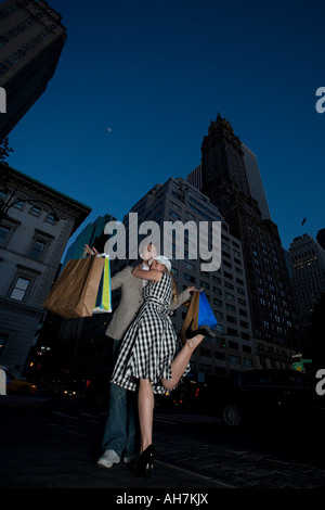 Basso angolo vista di una giovane donna che abbraccia un giovane uomo sulla strada, la città di New York, New York, Stati Uniti d'America Foto Stock