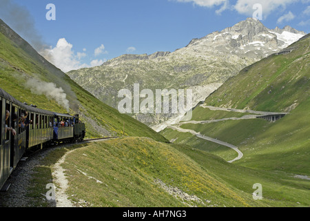 Treno a vapore che è passata attraverso il Passo della Furka Pass tunnel è voce verso Gletch Foto Stock