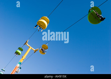 Persone in colorate gondole in movimento attraverso il cielo a Santa Cruz Boardwalk un parco di divertimenti di Santa Cruz, California Foto Stock