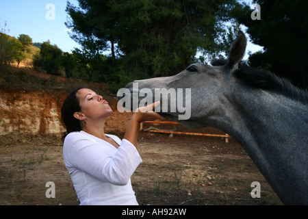 Giovane donna ad accarezzarle il cavallo Foto Stock