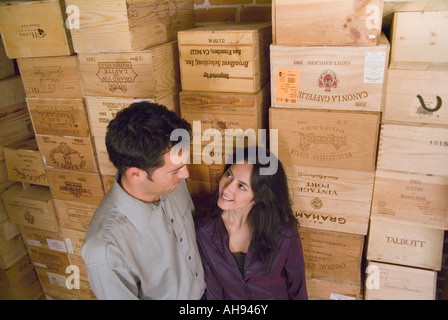 Una giovane coppia si erge contro le casse di vino Foto Stock