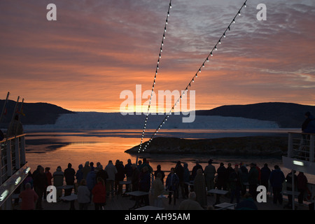 Stagliano passeggeri su una nave da crociera la vista spettacolare ghiacciaio Eqip presso sunrise a Disko Bay sulla costa occidentale della Groenlandia Foto Stock