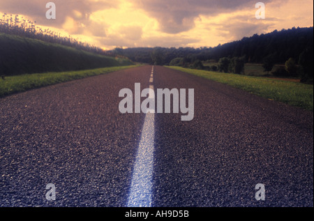 Un solitario country road leadning in infinite Foto Stock